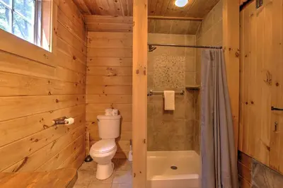 a wooden bathroom with a toilet and a shower at Lofty Willows Treehouse by Amish Country Lodging in Millersburg