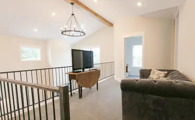 a living room with a couch and a flat screen tv at Farmhouse Suites by Amish Country Lodging in Millersburg