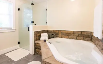a bathroom with a large tub and a shower at Farmhouse Suites by Amish Country Lodging in Millersburg