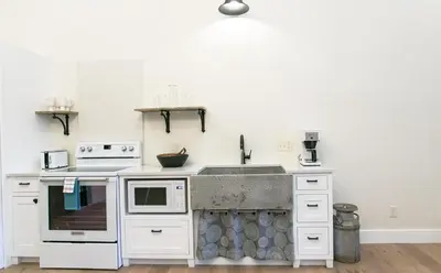 a kitchen with a sink and a stove at Farmhouse Suites by Amish Country Lodging in Millersburg