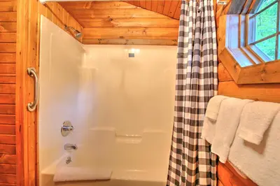 a bathroom with a shower and a shower curtain at Grapevine Cabin by Amish Country Lodging in Millersburg