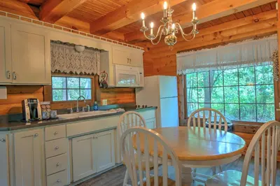 a kitchen with a table and chairs and a dining room at Grapevine Cabin by Amish Country Lodging in Millersburg