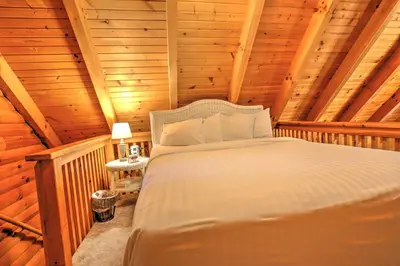 a bedroom with a bed in a log cabin at Grapevine Cabin by Amish Country Lodging in Millersburg