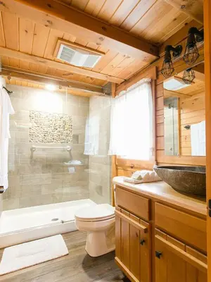 a bathroom with a toilet and a shower and a sink at Evergreen Cabin by Amish Country Lodging in Millersburg