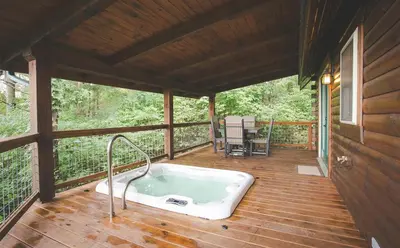 a bath tub sitting on a deck in a cabin at Evergreen Cabin by Amish Country Lodging in Millersburg