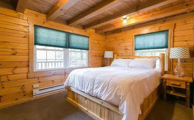 a bedroom with a bed in a log cabin at Evergreen Cabin by Amish Country Lodging in Millersburg