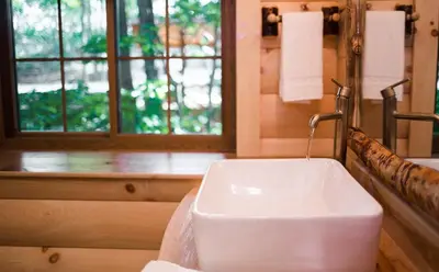 a white sink in a bathroom with a window at Treehouse #1 by Amish Country Lodging in Millersburg