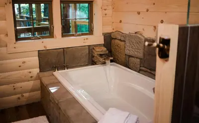 a bathroom with a large tub in a cabin at Treehouse #1 by Amish Country Lodging in Millersburg