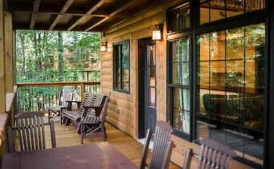 a screened in porch with a table and chairs at Treehouse #1 by Amish Country Lodging in Millersburg