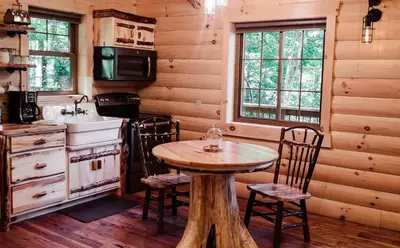a kitchen with a table and chairs in a cabin at Treehouse #0 by Amish Country Lodging in Millersburg