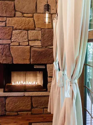 a stone wall with a fireplace in a room at Treehouse #0 by Amish Country Lodging in Millersburg