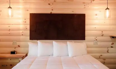 a bedroom with a white bed with a wooden wall at Treehouse #2 by Amish Country Lodging in Millersburg