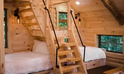 a tree house with a bed and stairs in it at Treehouse #2 by Amish Country Lodging in Millersburg