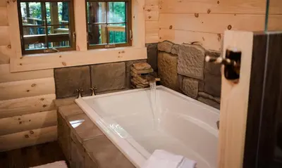 a bathroom with a large tub in a cabin at Treehouse #2 by Amish Country Lodging in Millersburg