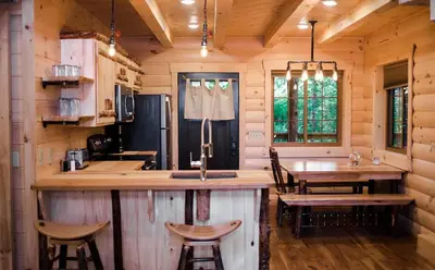 a kitchen with a bar and a table in a cabin at Treehouse #2 by Amish Country Lodging in Millersburg
