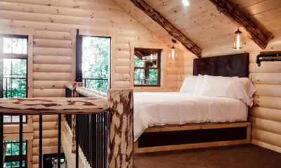 a bedroom with a bed in a log cabin at Treehouse #3 by Amish Country Lodging in Millersburg