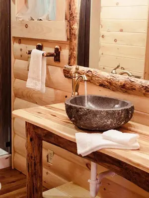 a bathroom with a sink in a log cabin at Treehouse #8 by Amish Country Lodging in Millersburg
