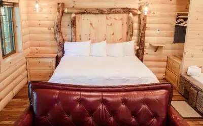 a bedroom with a bed with a leather seat at Treehouse #7 by Amish Country Lodging in Millersburg