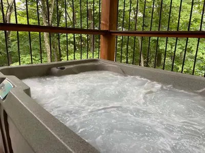 a jacuzzi tub with water in a balcony at Treehouse #7 by Amish Country Lodging in Millersburg
