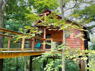 a tree house in the woods with a deck at Treehouse #6 by Amish Country Lodging in Millersburg