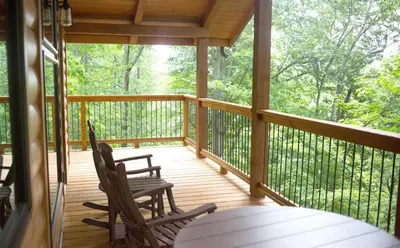 a screened in porch with two chairs and a table at Treehouse #6 by Amish Country Lodging in Millersburg