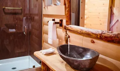 a bathroom with a sink in a log cabin at Treehouse #5 by Amish Country Lodging in Millersburg