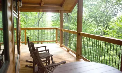 a screened in porch with two chairs and a table at Treehouse #5 by Amish Country Lodging in Millersburg