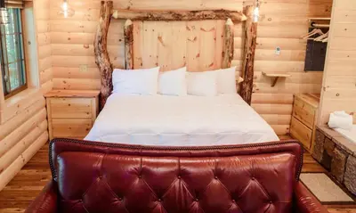 a bedroom with a bed with a leather seat at Treehouse #4 by Amish Country Lodging in Millersburg