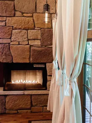 a stone wall with a fireplace in a room at Treehouse #4 by Amish Country Lodging in Millersburg