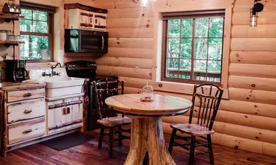 a kitchen with a table and chairs in a cabin at Treehouse #4 by Amish Country Lodging in Millersburg