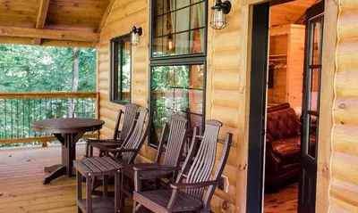 a porch with chairs and a table in a cabin at Treehouse #4 by Amish Country Lodging in Millersburg