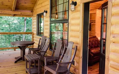 a porch with chairs and a table in a cabin at Treehouse #4 by Amish Country Lodging in Millersburg