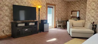 a living room with a tv and a couch and a chair at Victorian Suite by Amish Country Lodging in Millersburg