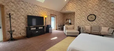 a living room with a television and a couch and chairs at Victorian Suite by Amish Country Lodging in Millersburg