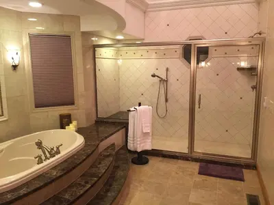 a bathroom with a shower and a tub and a sink at Victorian Suite by Amish Country Lodging in Millersburg