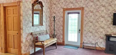a living room with a chair and a mirror at Victorian Suite by Amish Country Lodging in Millersburg
