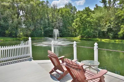 two chairs and a table on a deck with a fountain at Waterview Lodge by Amish Country Lodging in Millersburg