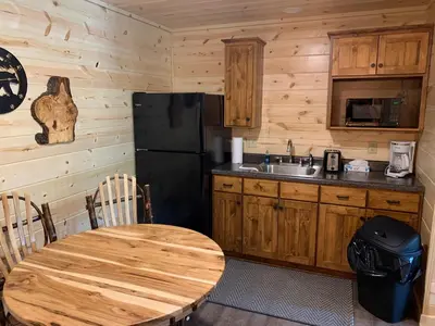 a wooden kitchen with a wooden table and a refrigerator at Waterview Lodge by Amish Country Lodging in Millersburg