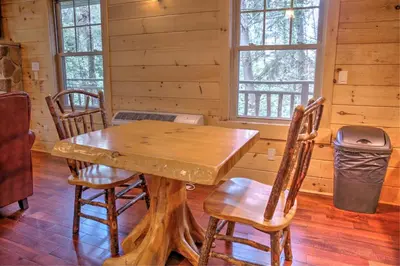 a dining room with a wooden table and chairs at Whispering Pines Treehouse by Amish Country Lodging in Millersburg
