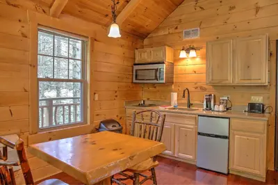 a kitchen with a wooden table in a cabin at Whispering Pines Treehouse by Amish Country Lodging in Millersburg