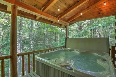 a hot tub on the deck of a tree house at Wild Rose Cabin by Amish Country Lodging in Millersburg