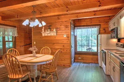 a kitchen and dining room with a table and chairs at Wild Rose Cabin by Amish Country Lodging in Millersburg