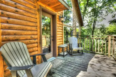 a porch with two rocking chairs on a cabin at Wild Cherry Treehouse by Amish Country Lodging in Millersburg