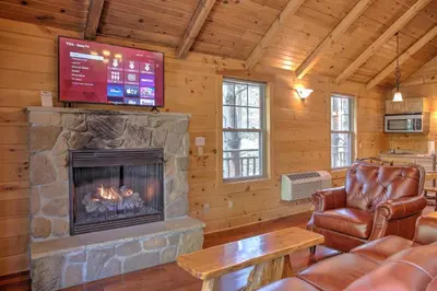 a living room with a fireplace and a tv at Wild Cherry Treehouse by Amish Country Lodging in Millersburg