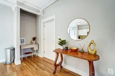 a room with a table and a mirror on a wall at The Republic Retreat Walk to Washington Park! in Cincinnati