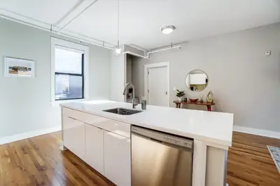 an empty kitchen with white cabinets and a sink at The Republic Retreat Walk to Washington Park! in Cincinnati
