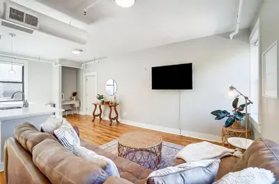 a living room with a couch and a flat screen tv at The Republic Retreat Walk to Washington Park! in Cincinnati