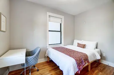 a bedroom with a bed and a desk and a window at The Republic Retreat Walk to Washington Park! in Cincinnati