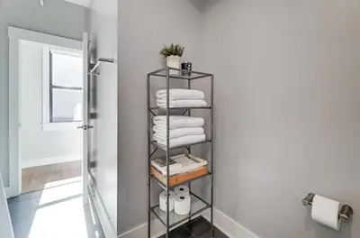 a bathroom with a metal towel rack with towels at The Republic Retreat Walk to Washington Park! in Cincinnati