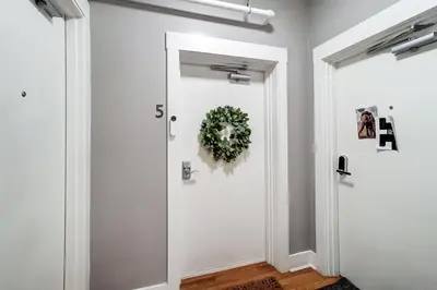a hallway with a white door with a wreath on it at The Republic Retreat Walk to Washington Park! in Cincinnati